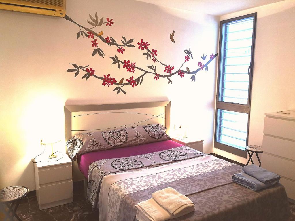 1 dormitorio con 1 cama con una rama en la pared en Duplex Near Center Wifi, en Valencia