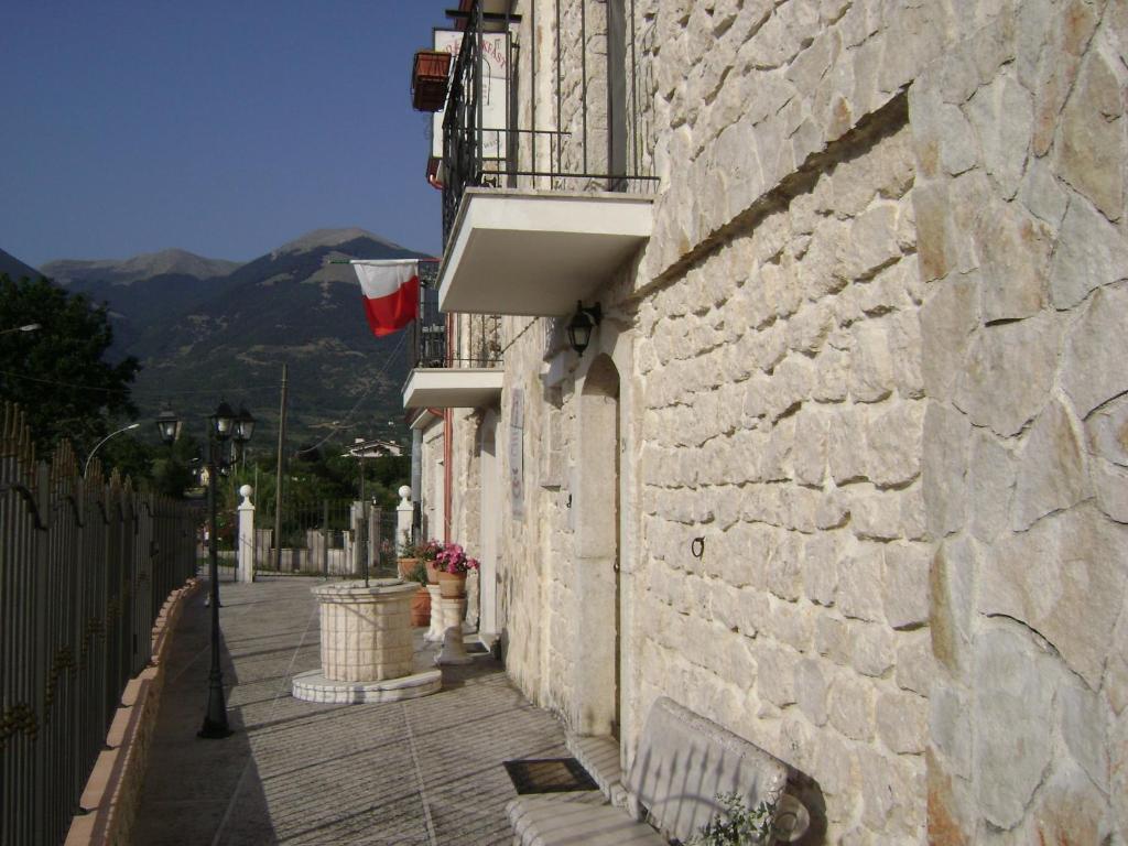 a stone building with a bench on a street at The Wishing Well in Gallinaro