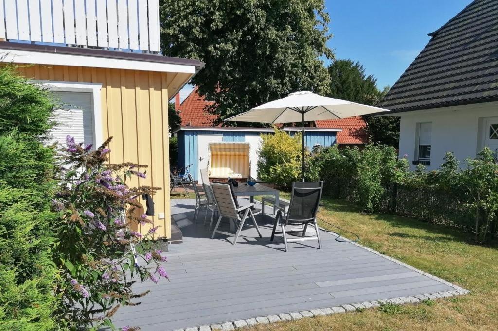 a patio with a table and chairs and an umbrella at Darß Idyll in Prerow
