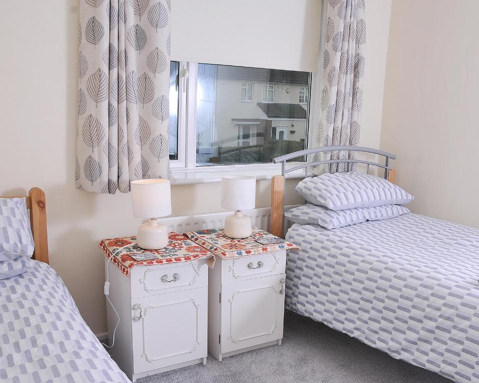 a bedroom with two twin beds and a window at 5beds-2WC-2shwr-secure 2 van off-road-Biz WiFi-washer-dryer in Corby
