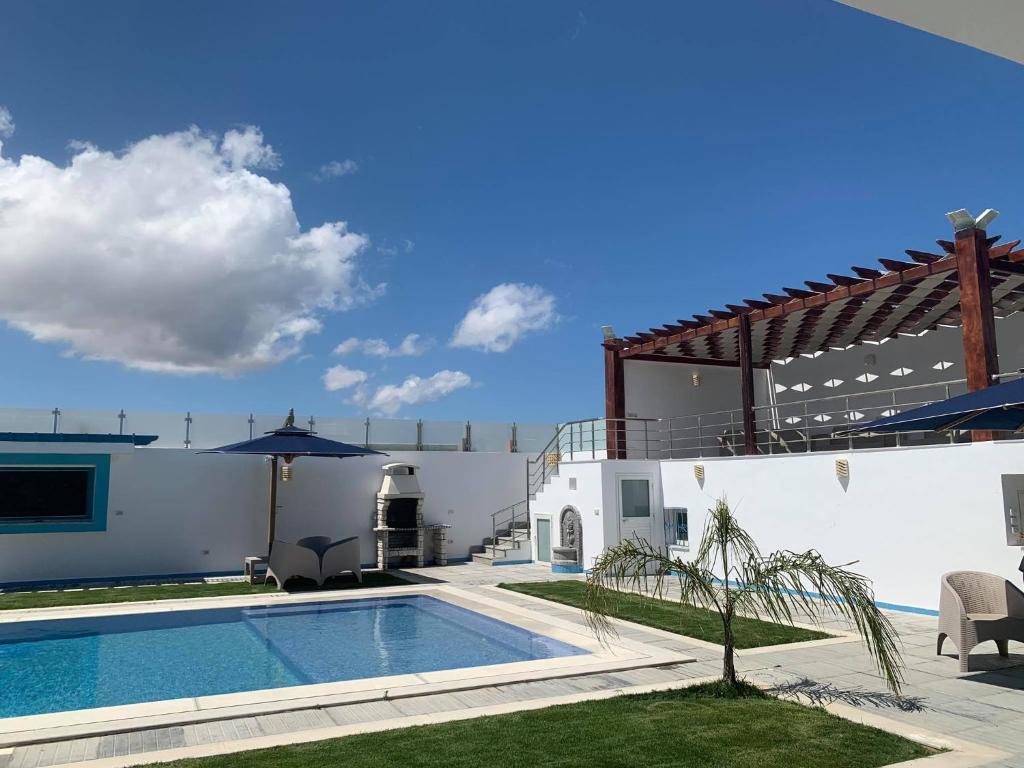 a villa with a swimming pool and a house at une superbe villa avec piscine à Dar allouche kélibia in Kelibia