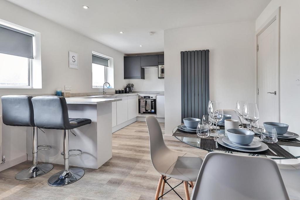 een keuken en eetkamer met een tafel en stoelen bij Newly Renovated 3 Bed Apartment with Parking by Ark SA in Sheffield