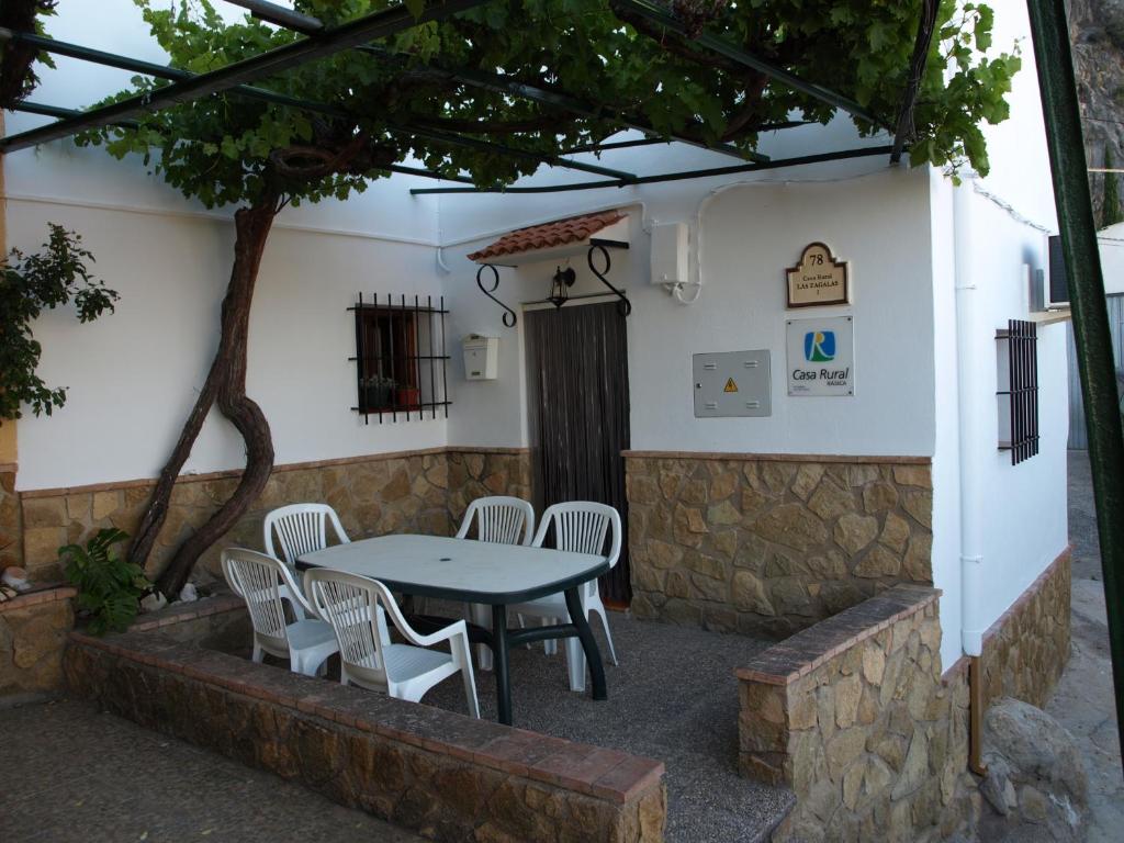 un patio con mesa, sillas y un árbol en Alojamiento Rural Las Zagalas, en Tíscar