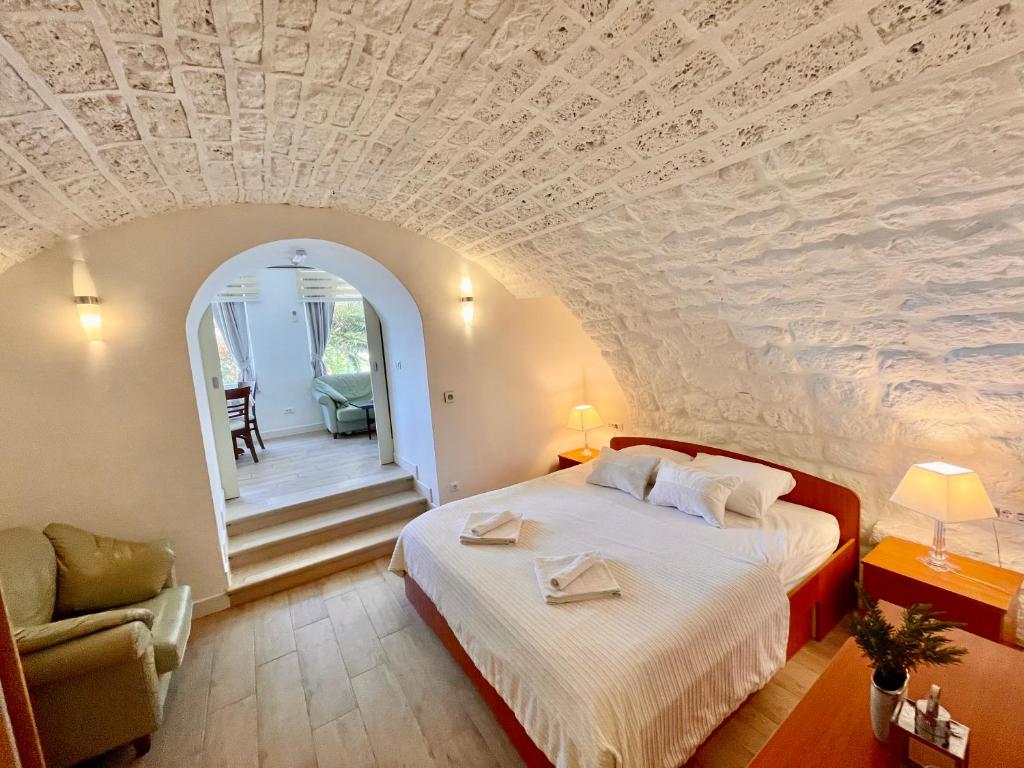 sypialnia z dużym łóżkiem i kamiennym sufitem w obiekcie Ida 3 Apartments w Dubrowniku