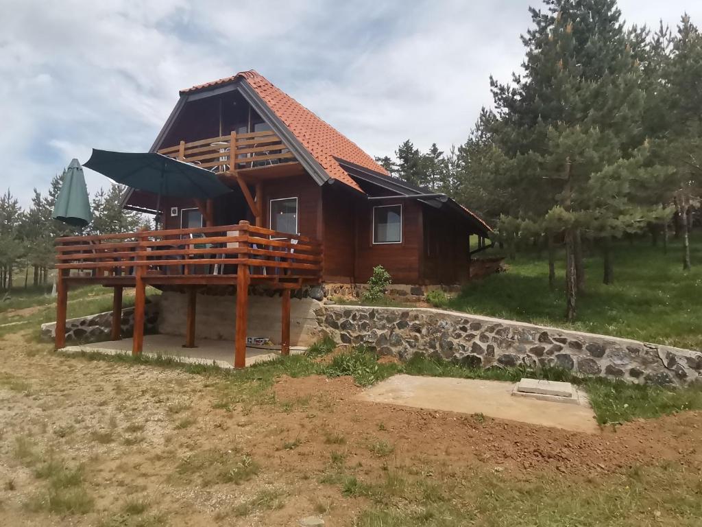 a log cabin with a stone wall at Careva voda 1 in Dobroselica