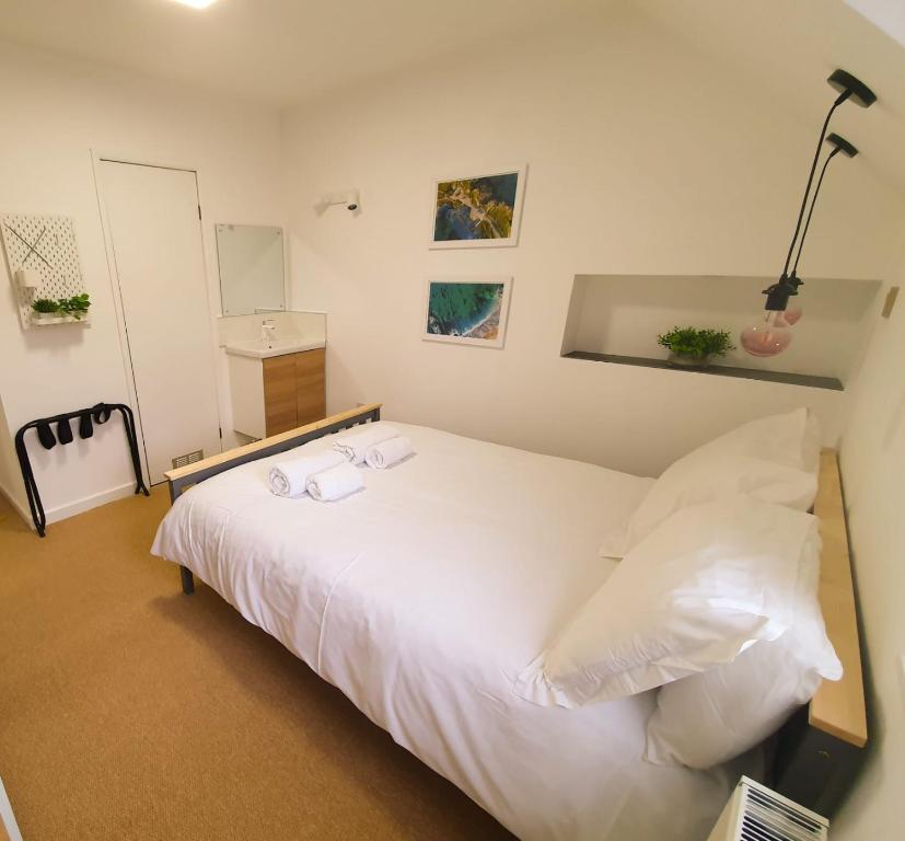 a bedroom with a white bed with two towels on it at Sea Bed Guesthouse in Newquay