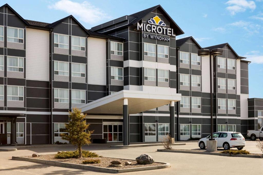 a hotel with a car parked in front of it at Microtel Inn & Suites by Wyndham Lloydminster in Lloydminster