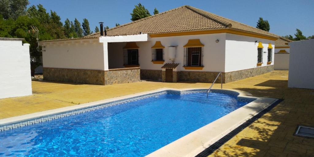a villa with a swimming pool in front of a house at Alojamiento rural " Las Carmenes " in Algar