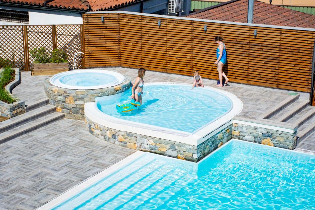 a group of people in a swimming pool at Hotel Bungalows Europa in Domaso