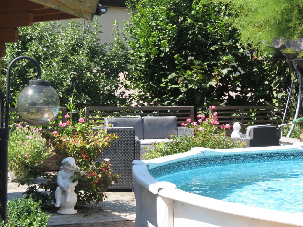 una piscina en un patio con flores en B&B Andrey, en Marly-le-Grand