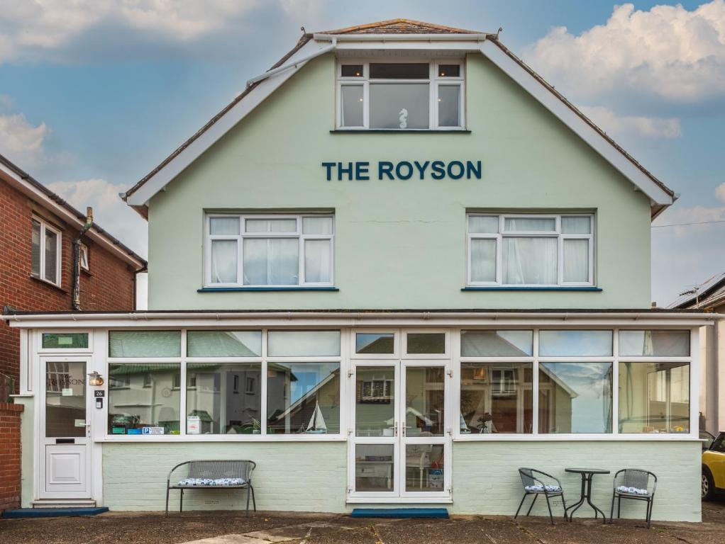 a white building with a sign that reads the rolexon at The Royson Guest House in Shanklin