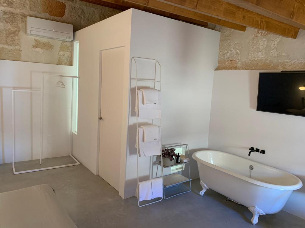 Baño blanco con bañera y lavamanos en Fragile Hotel en Ciutadella
