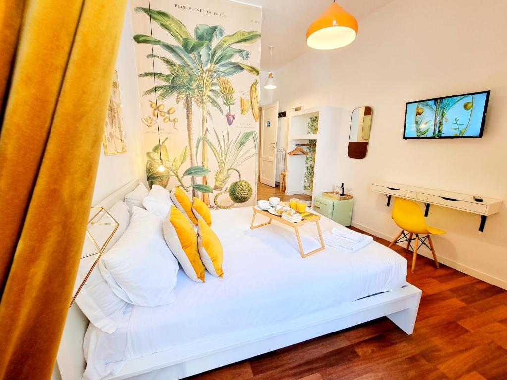una camera da letto con un letto bianco con cuscini gialli di Napoli Tree - Lungomare a Napoli