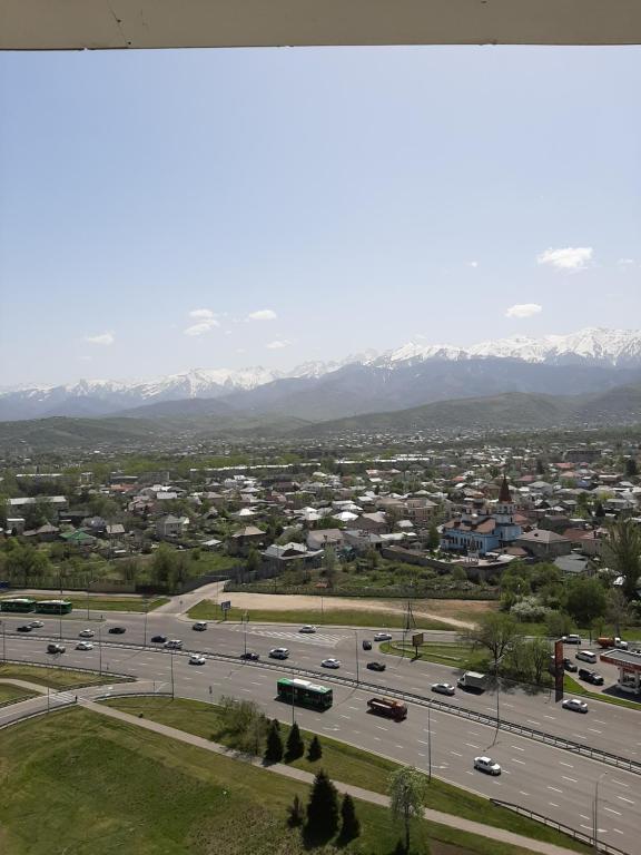Une ville avec une autoroute et des montagnes en arrière-plan dans l'établissement Апартаменты с видом на горы, à Almaty