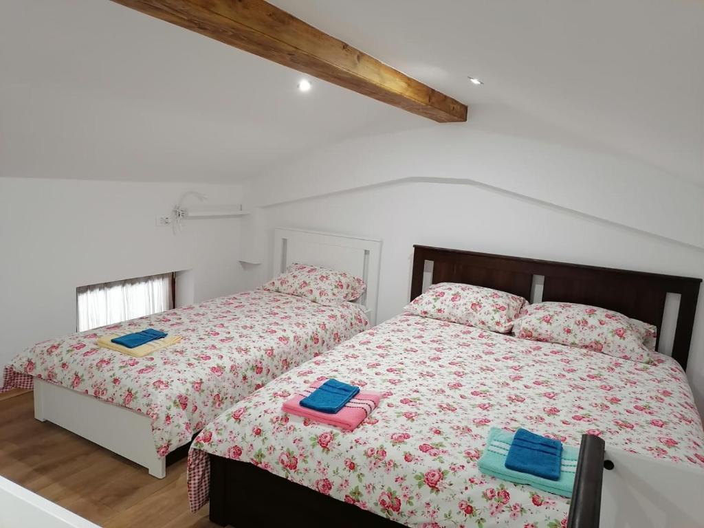 um quarto com 2 camas e toalhas em Hiša pod Gradičem em Kobarid
