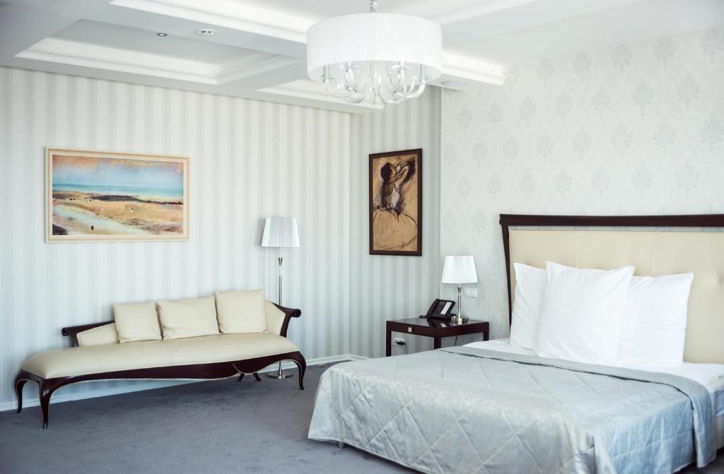 a bedroom with a bed and a chair and a chandelier at Ost West Club in Samara