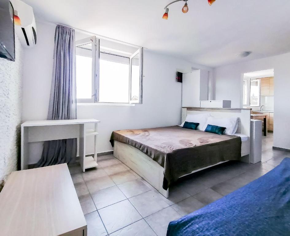 a bedroom with two beds and a window at Apartments Siesta in Tivat