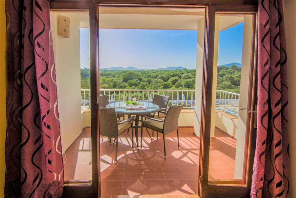Habitación con vistas a un balcón con mesa y sillas. en Apartments Residencial Cala Ferrera, en Cala Ferrera