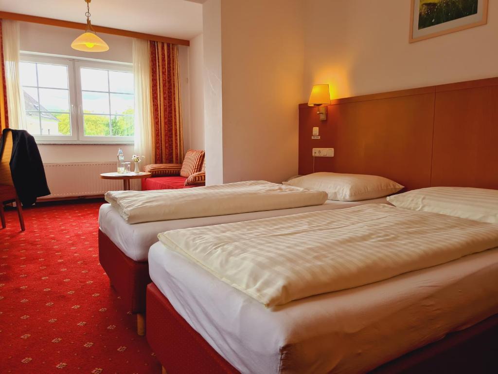 a hotel room with two beds and a window at Hotel Wirt im Feld in Steyr