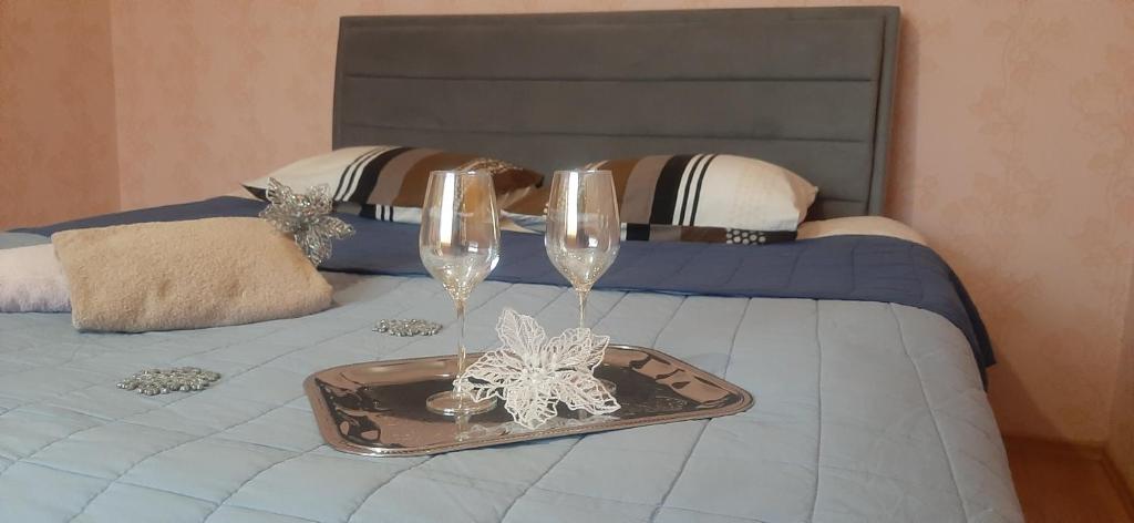 a tray with two wine glasses on a bed at Kandavas 2 in Daugavpils