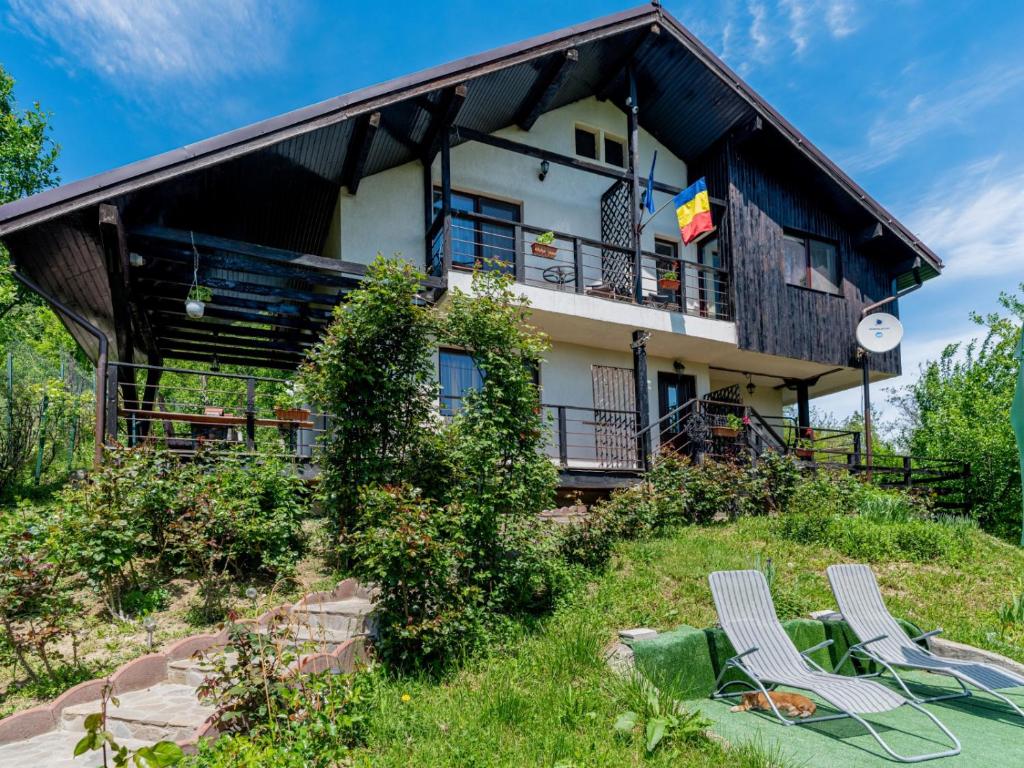 a house on top of a hill with two chairs at Casuta cu Trandafiri in Slănic