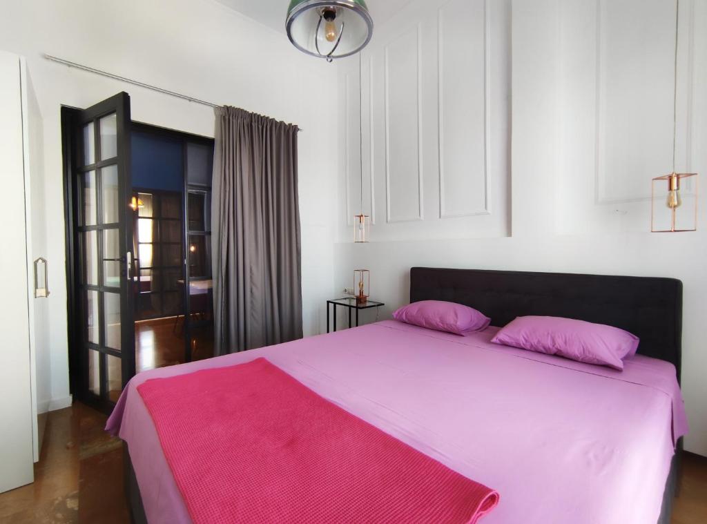 een slaapkamer met een roze bed en een roze deken bij Luxury Apartments Aristotelous in Thessaloniki