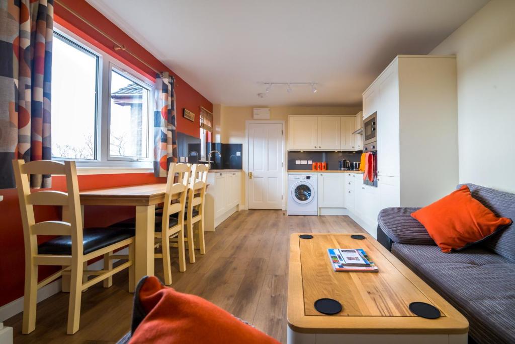 a kitchen and living room with a table and a couch at Suil Na Mara Studio in Lochinver