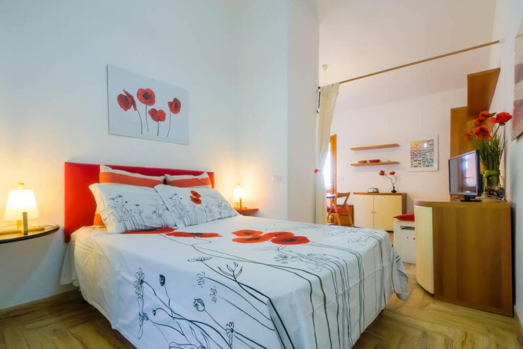 Un dormitorio con una cama con flores rojas. en West Sardinia - Bosa, en Magomadas
