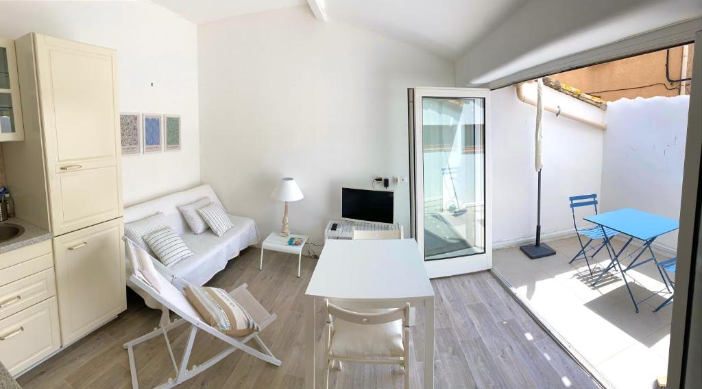 a living room with a white couch and a table at La petite maison bleue in Gruissan