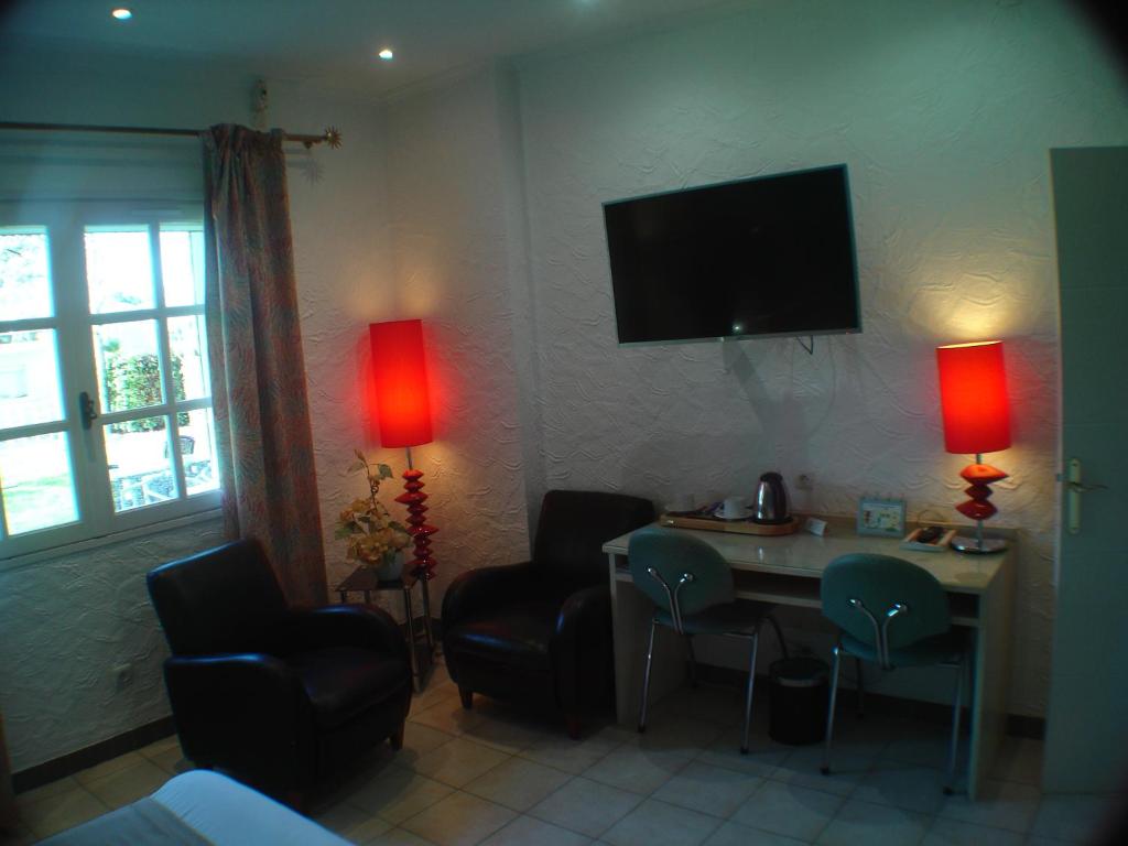 TV a/nebo společenská místnost v ubytování Logis Hôtel & Restaurant Le Fleurance