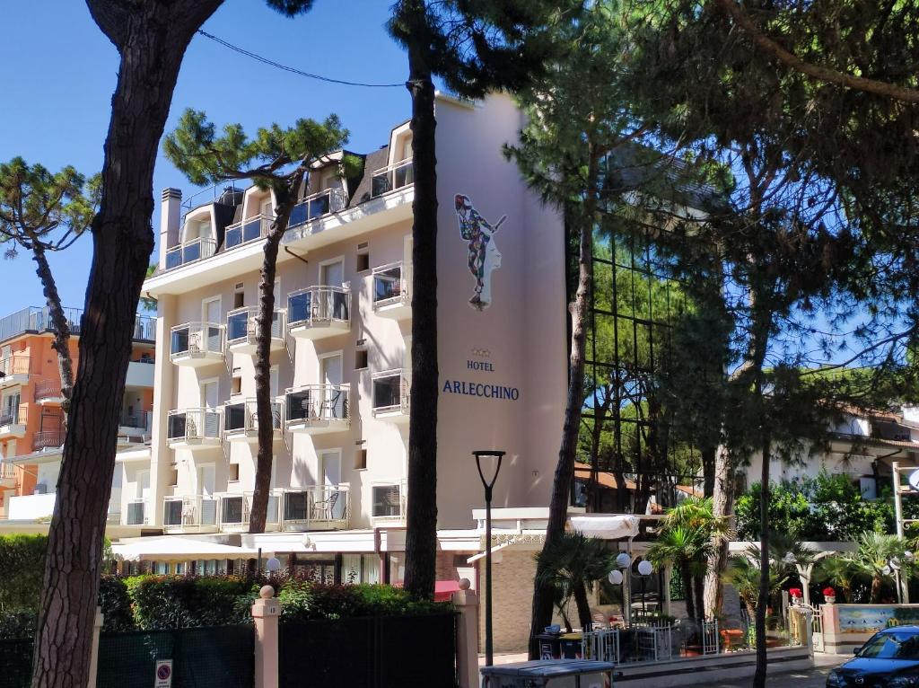 duży biały budynek z napisem w obiekcie Hotel Arlecchino w mieście Milano Marittima