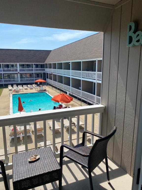 a balcony with two chairs and a swimming pool at Apartment in Royal Atlantic Beach Resort in Montauk