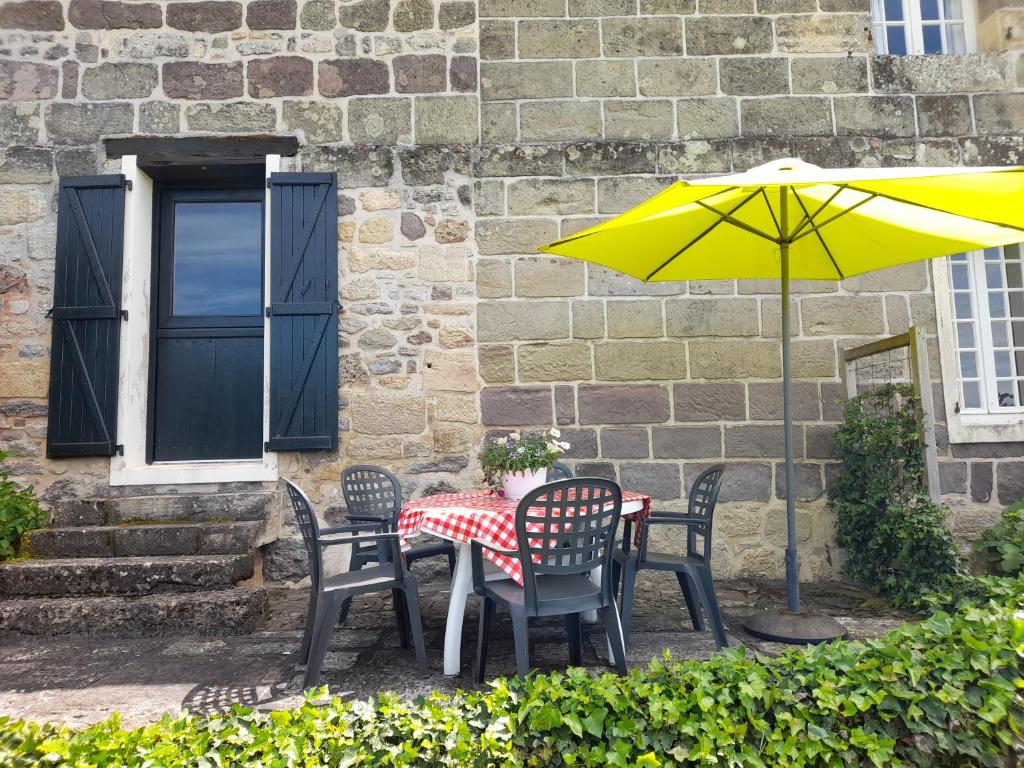 a table and chairs with a yellow umbrella at Domaine Leyvinie, gite Mourvedre, close to the Dordogne in Perpezac-le-Blanc