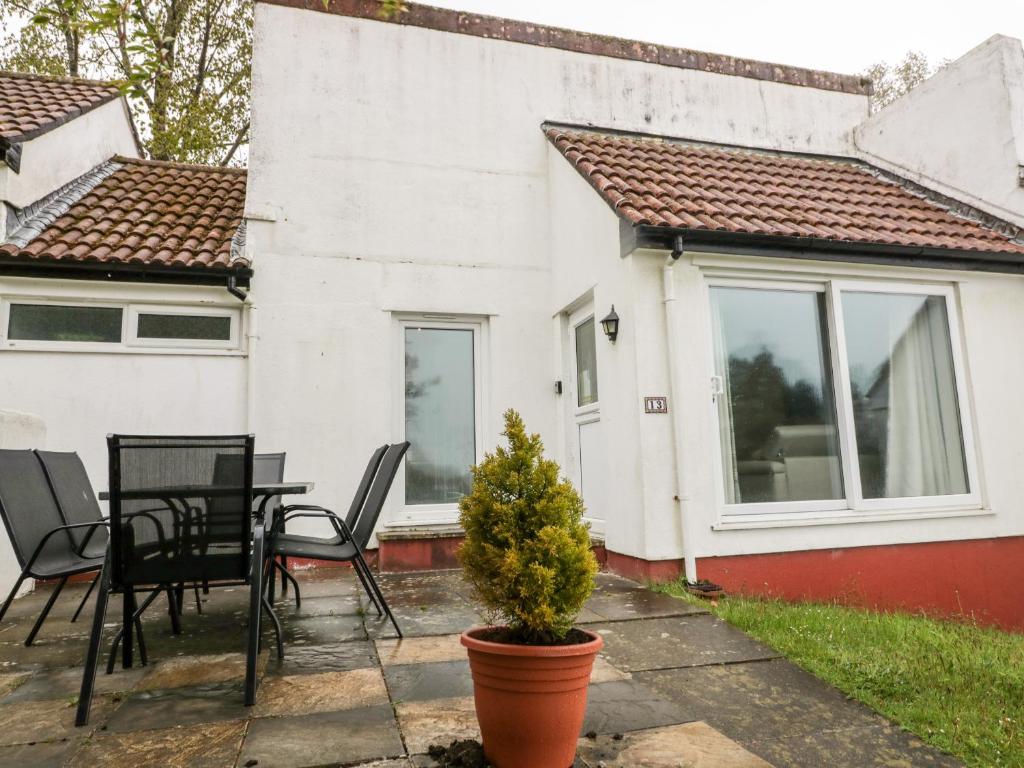 a patio with a table and chairs in front of a house at 13 Manorcombe Bungalows in Callington