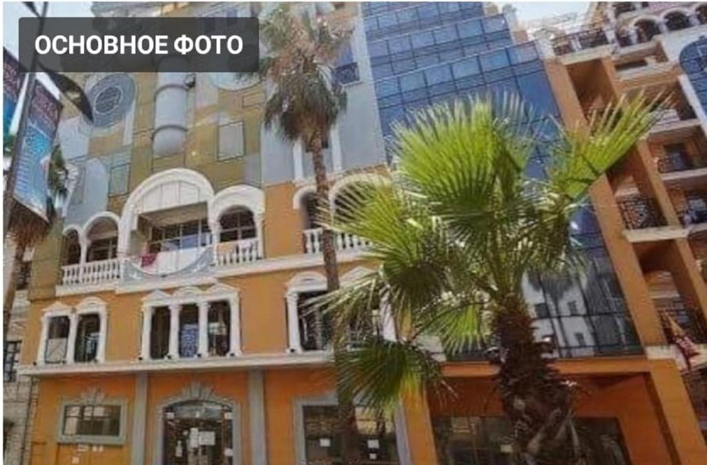 a building with palm trees in front of it at Apartament on Rustaveli in Batumi