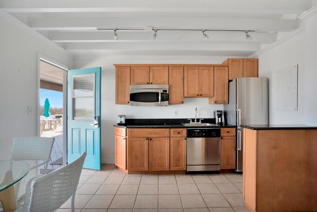 
a kitchen with a refrigerator, stove, sink and microwave at Driftwood Resort on the Ocean in Montauk
