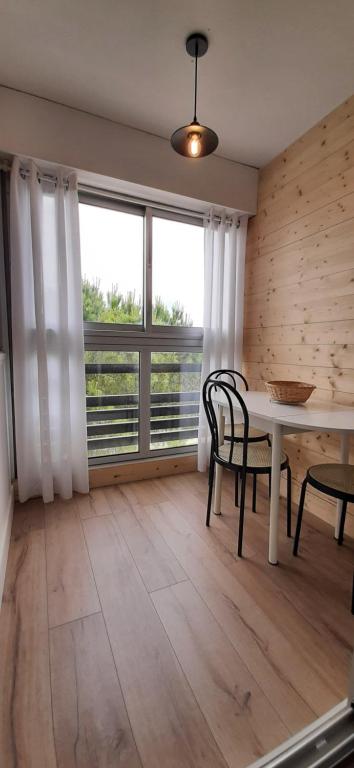 ein Esszimmer mit einem Tisch, Stühlen und einem Fenster in der Unterkunft LE LIBERTE - Studio cabine à 2 pas de la plage et du port in Saint-Cyprien
