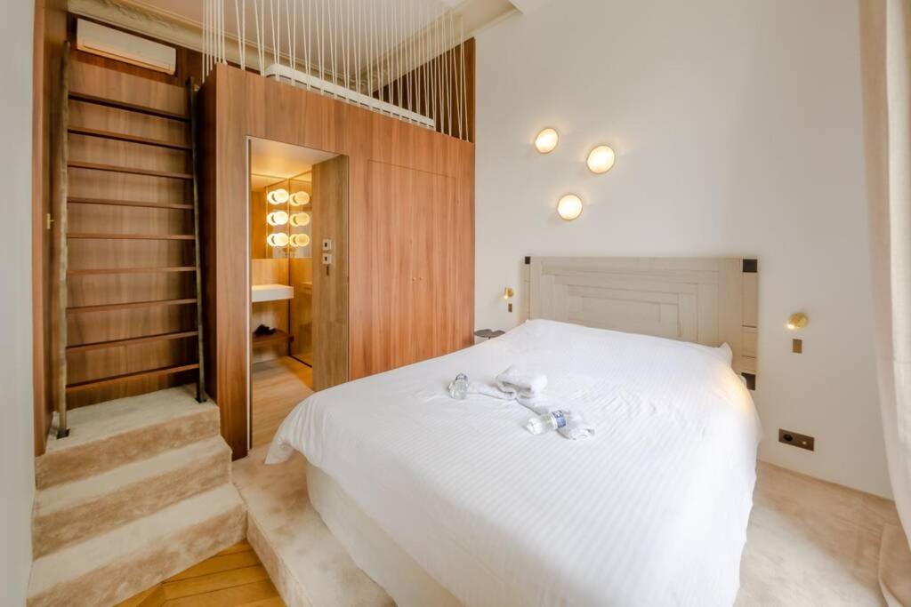 een slaapkamer met een wit bed en een trap bij Appartement de standing 2 - tour Eiffel/Invalides in Parijs
