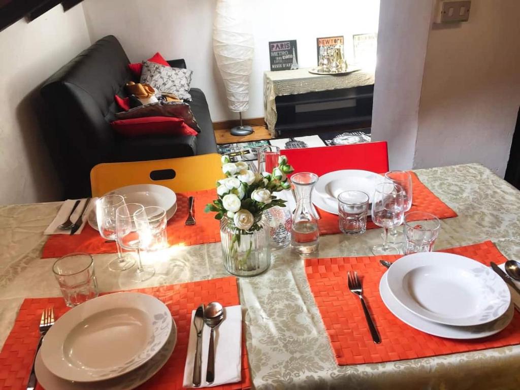 uma mesa de jantar com pratos e copos e uma toalha de mesa em 3-Tourist House Bologna-Mansarda - Self check-in em Bolonha
