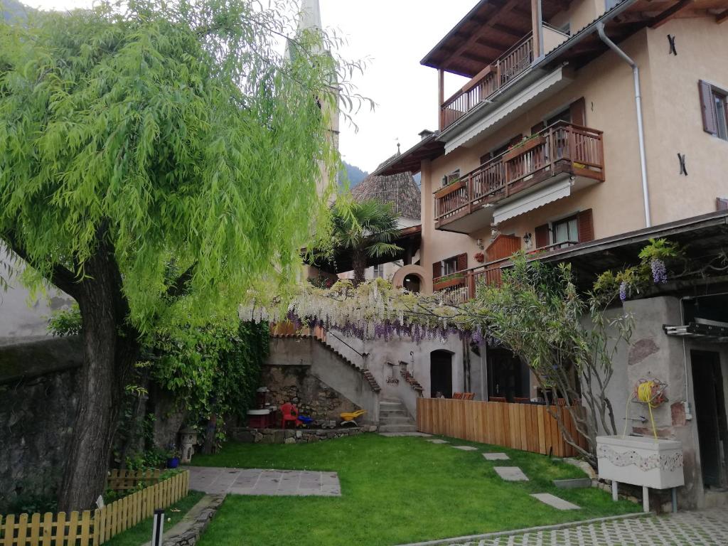 un cortile di un edificio con un albero di fronte di Haus Möltner - Apartment 1927 a Caldaro
