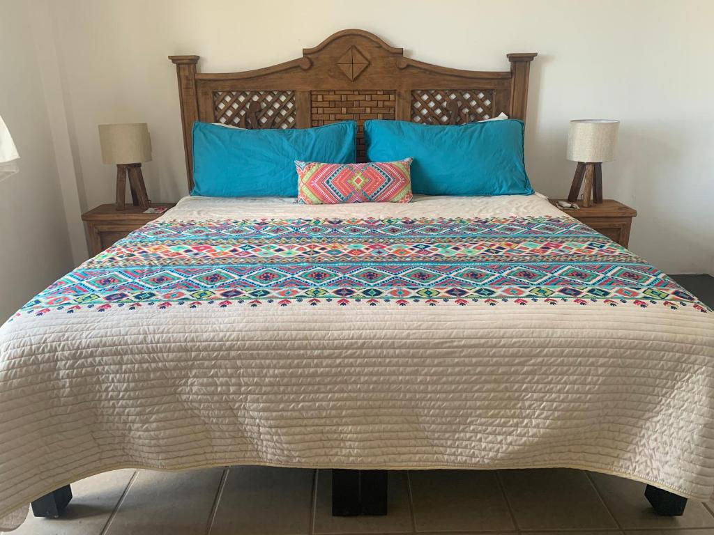 um quarto com uma cama grande e almofadas azuis em Breeze by Casa Maty San Pancho em San Francisco