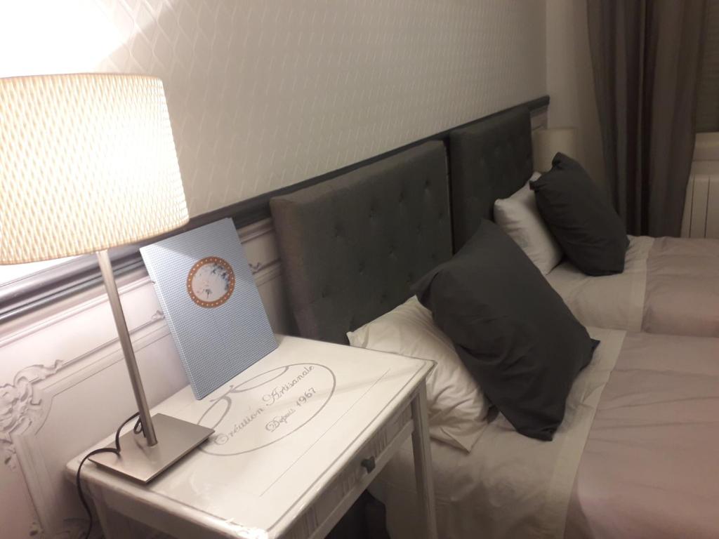 a hotel room with a bed and a table with a lamp at Le boudoir de la Lys in Saint-Venant