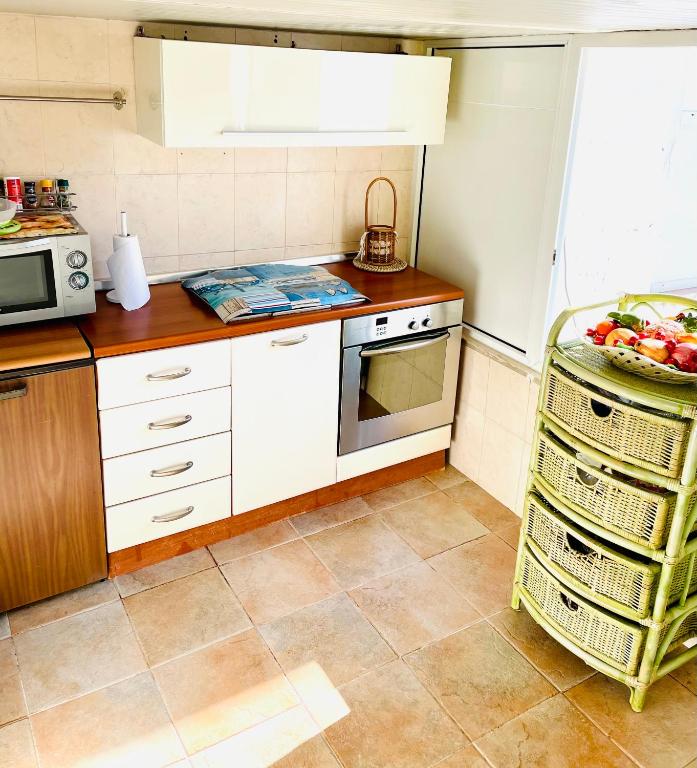 a kitchen with white cabinets and a plate of fruit on the counter at Relax House in Bari