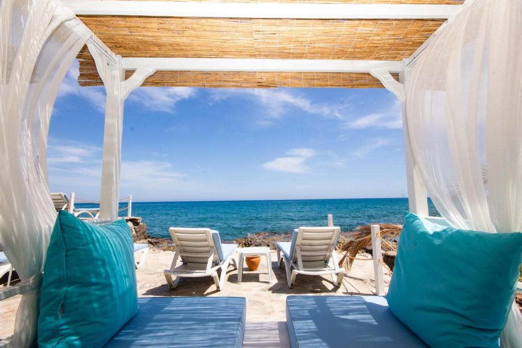 a gazebo on the beach with chairs and the ocean at MOJO OTEL BEACH in Erdemli