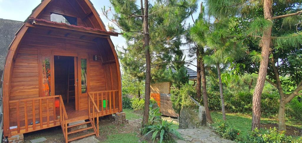 a wooden cabin in a forest with trees at Saung Orange Village in Bogor