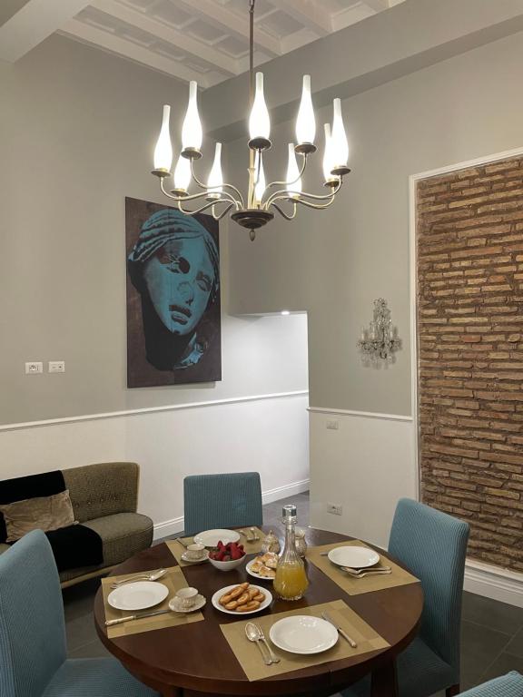 a dining room with a table with chairs and a chandelier at Mia roma centro in Rome