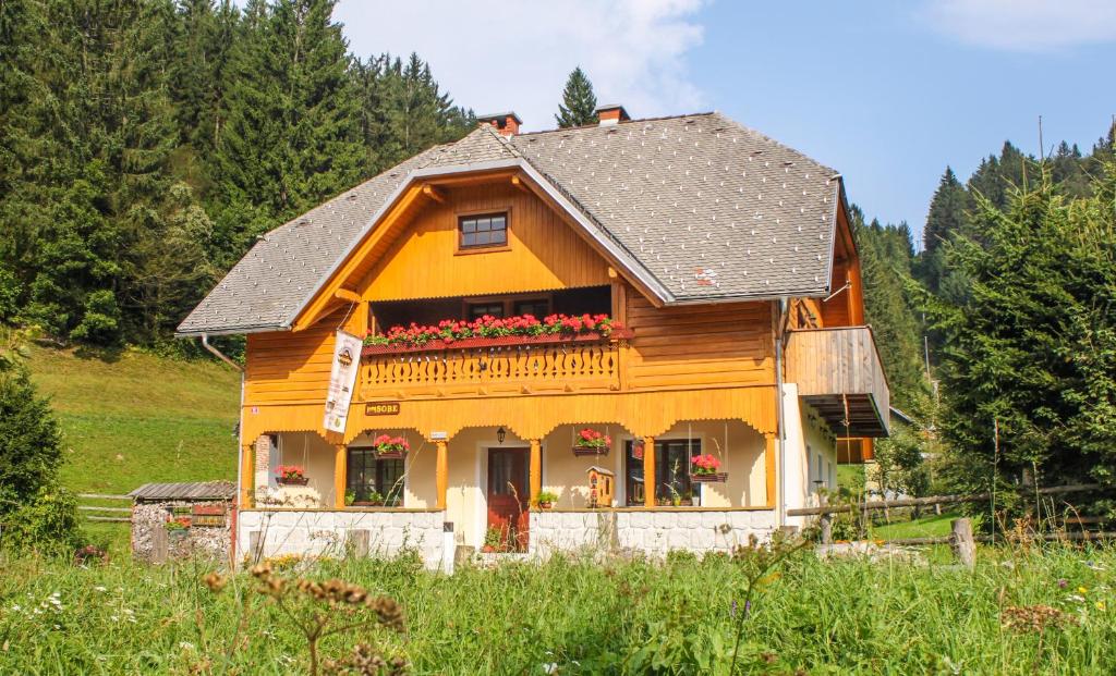 uma pequena casa de madeira com flores na janela em Homestead Zatrnik near Bled em Bled