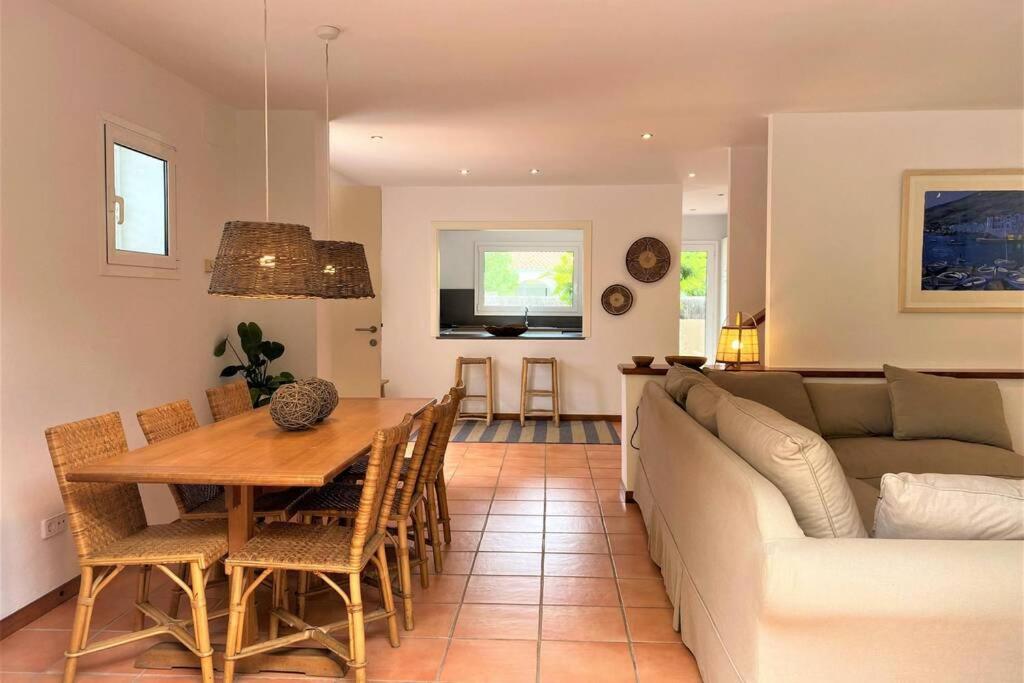 a living room with a couch and a dining room table at LLEBEIG -Casa mediterránea con gran jardín in Cadaqués