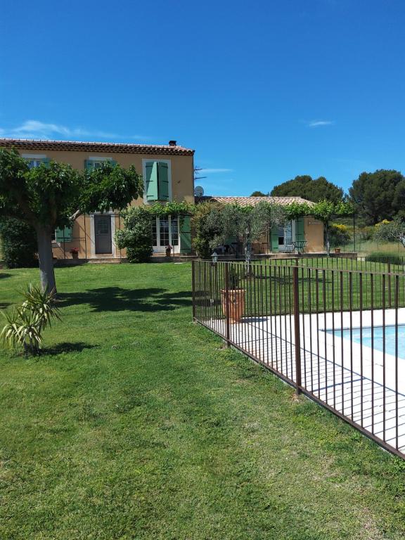 une maison avec une clôture à côté d'une piscine dans l'établissement Gite La RESTANCO, à Mouriès