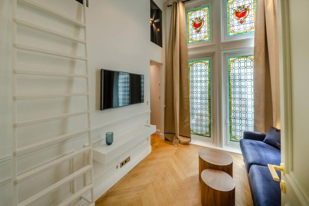 - un salon avec un canapé bleu et des vitraux dans l'établissement Appartement de standing 5 - tour Eiffel/Invalides, à Paris